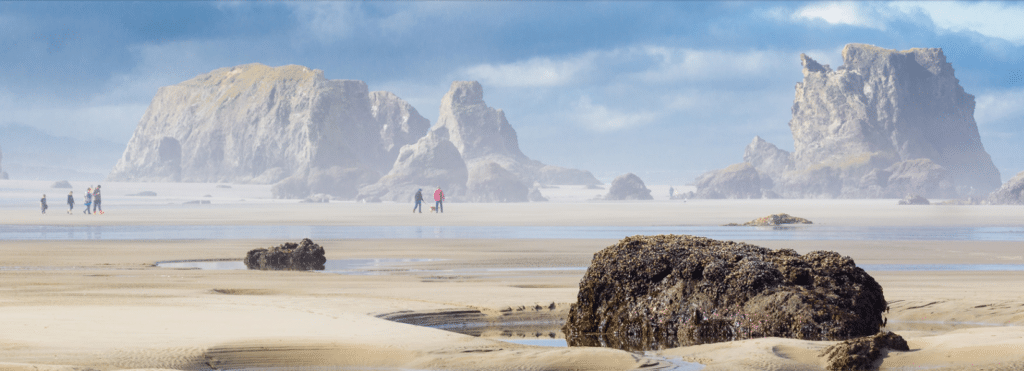 While staying at top Bandon, Oregon Hotels, people enjoying walking on the iconic beach in Bandon