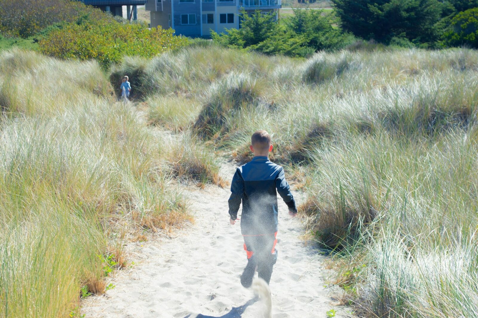 Best things to Do on the Oregon Coast This Summer 2 kids running back to the hotel on our private beach trail.