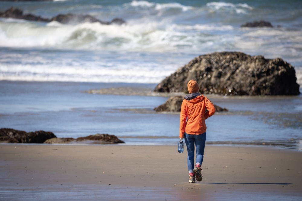 A traveler enjoys a solo hike along the rocky Oregon coastline.