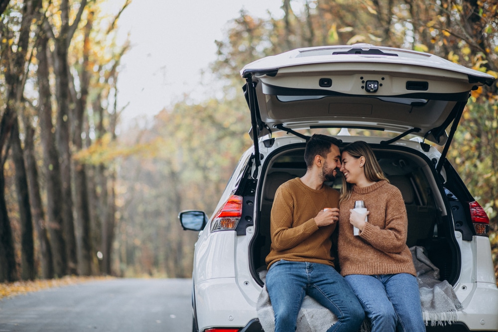 A couple snuggles in the hatch of their SUV while on the side of highway 101 in Oregon.