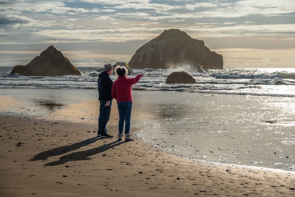 Places to Visit in Oregon, a couple stands on the coast looking the ocean