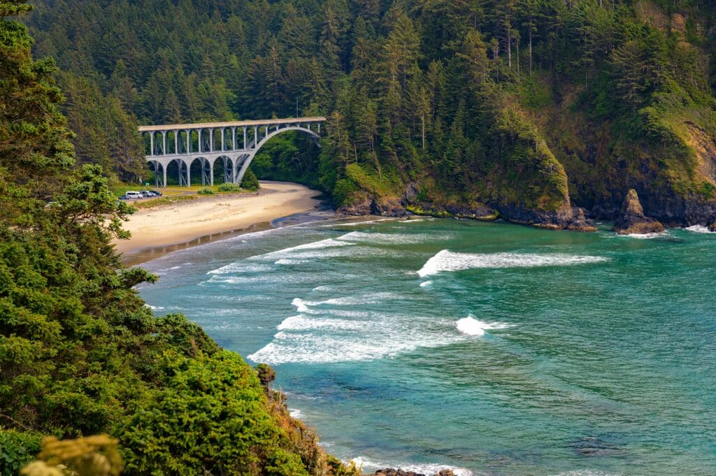 An arched bridge on Oregon Coast highway near Hecata Beach, ocean, forest. Oregon Coast Road trip.