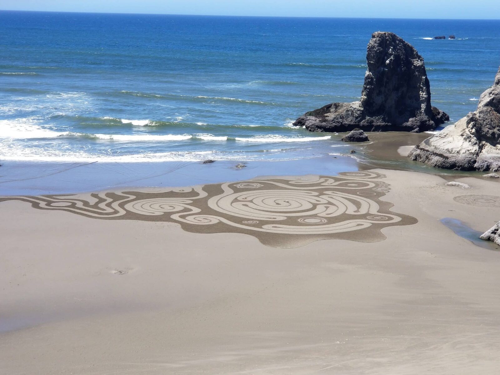 Intricate sand art being washed away by the tide at Circles in the Sand on the Oregon Coast.